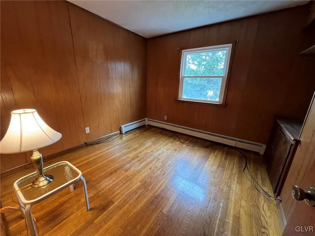 unfurnished room featuring light hardwood / wood-style floors and a baseboard radiator