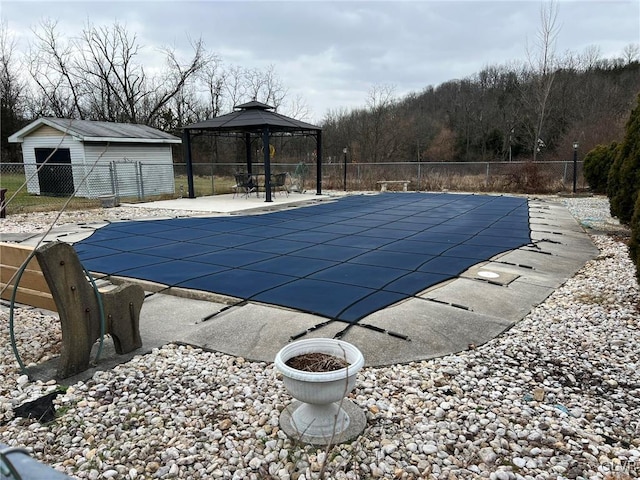 view of pool with a patio area, a gazebo, and an outdoor structure