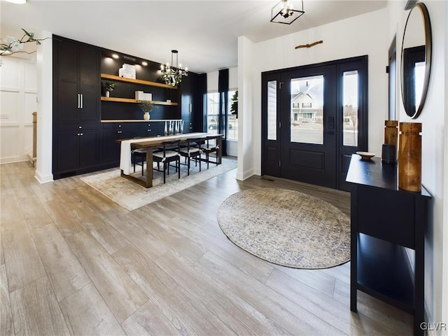 foyer with a chandelier and light wood-style flooring