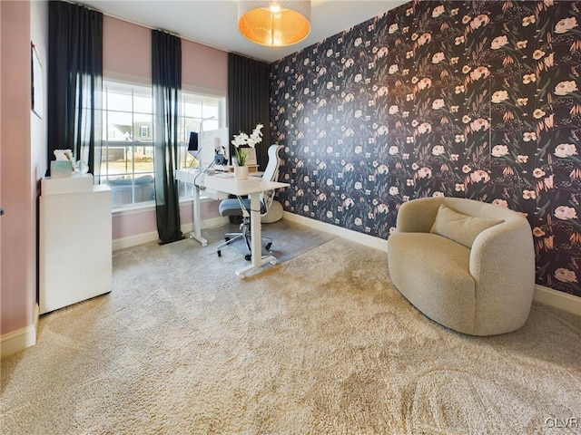 carpeted home office with wallpapered walls and baseboards