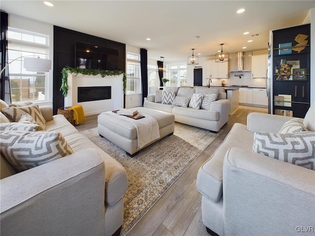 living room featuring light wood-type flooring, a fireplace, and recessed lighting