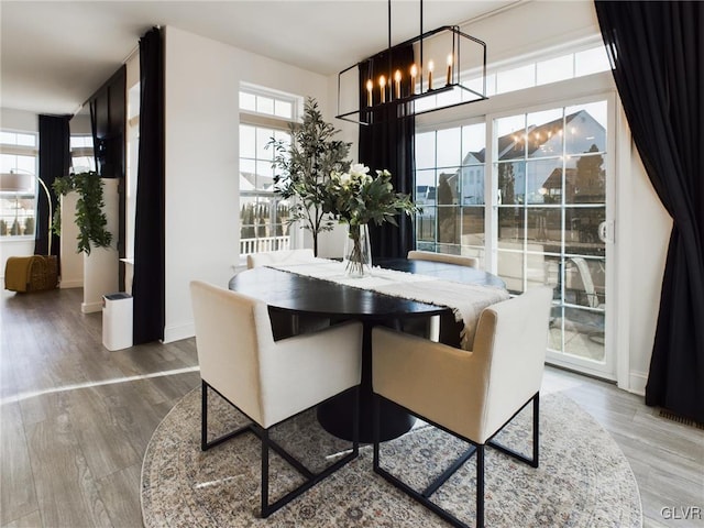 dining room with an inviting chandelier, baseboards, and wood finished floors