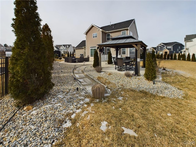 rear view of house featuring a residential view, a patio, a gazebo, and fence