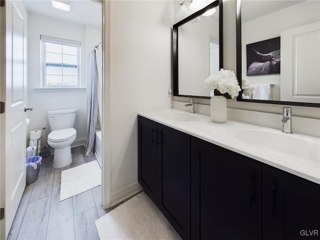 full bath with shower / bath combo, a sink, toilet, and double vanity