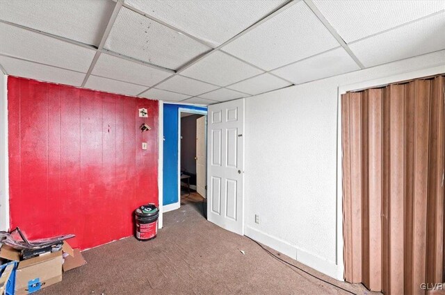 interior space featuring carpet floors and a paneled ceiling