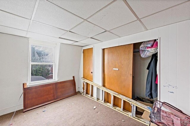 carpeted empty room with a paneled ceiling