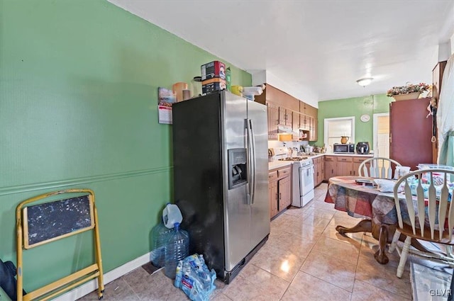 kitchen with light tile patterned floors and stainless steel appliances