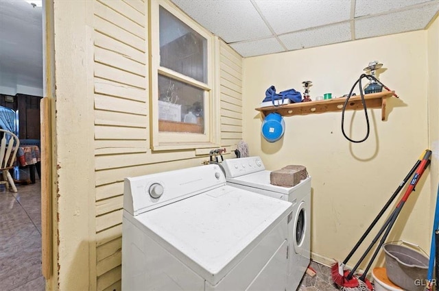 laundry room featuring wooden walls and washer and clothes dryer