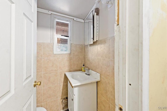 bathroom with vanity and tile walls