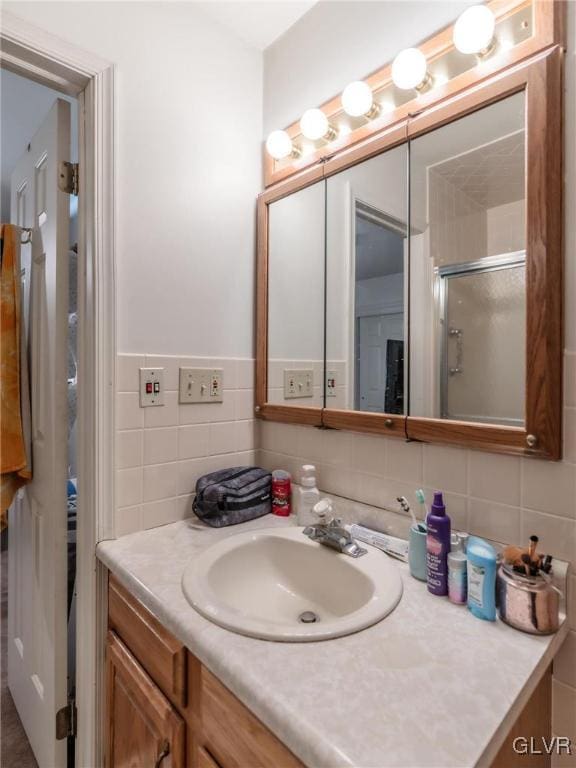 bathroom featuring vanity, tile walls, and a shower with shower door