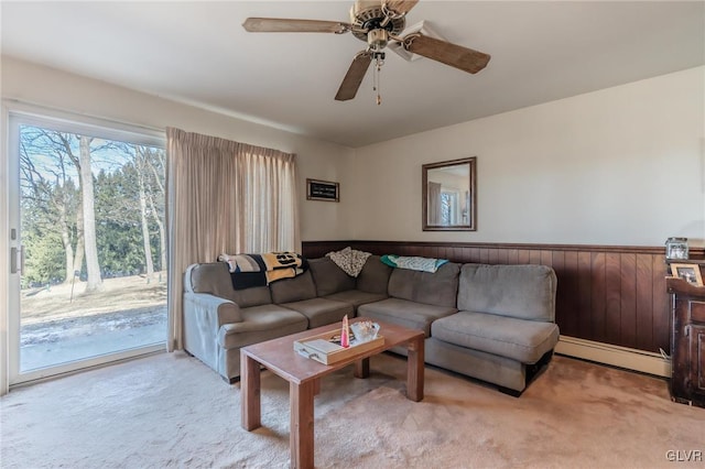 living room featuring ceiling fan, light colored carpet, and a baseboard heating unit