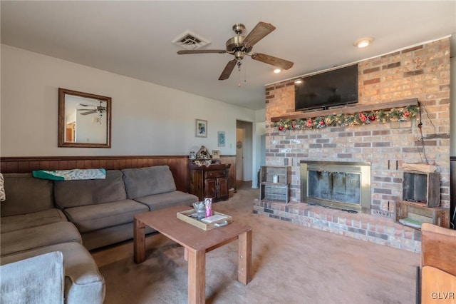 living room featuring a brick fireplace, carpet floors, and ceiling fan