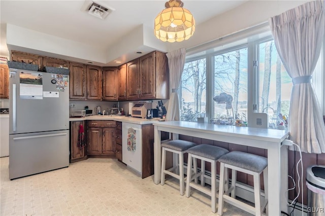 kitchen featuring pendant lighting and stainless steel fridge