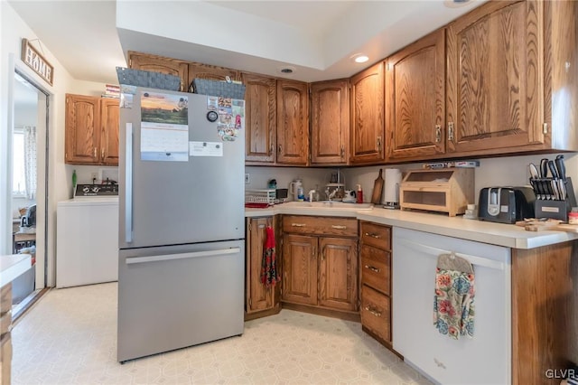 kitchen featuring washer / dryer and stainless steel refrigerator