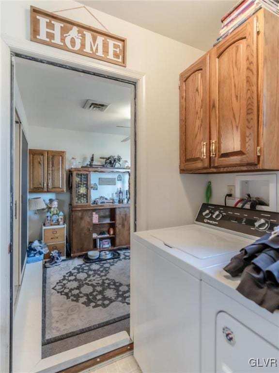 laundry room with cabinets and washing machine and clothes dryer