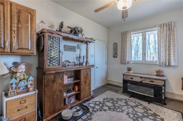 sitting room with baseboard heating and ceiling fan