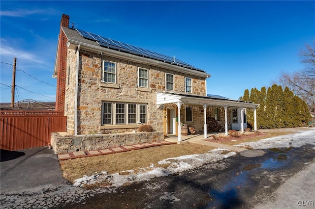 view of front of home featuring solar panels and a porch