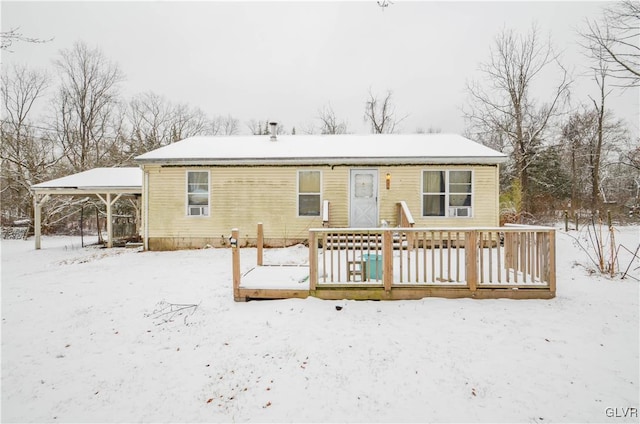 snow covered house with a wooden deck