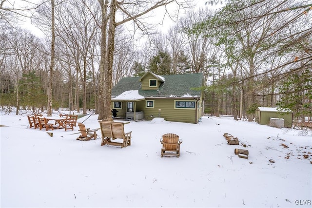 snow covered property with a storage shed