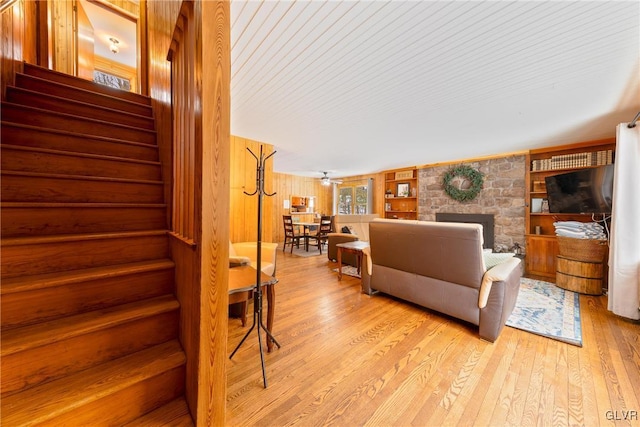 living room featuring light hardwood / wood-style floors and wood walls