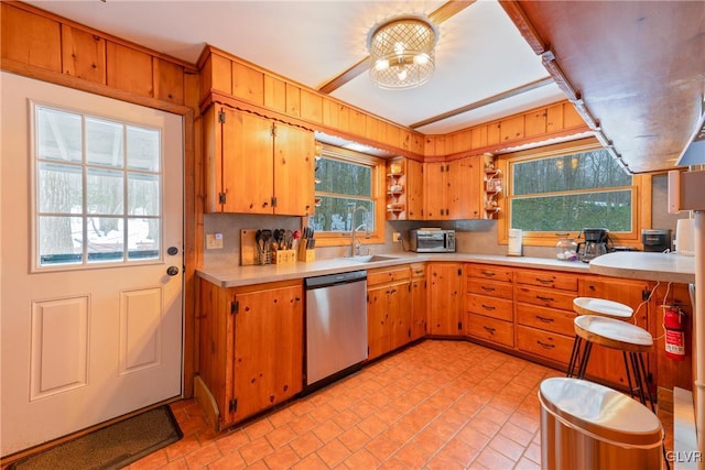 kitchen featuring an inviting chandelier, sink, and stainless steel dishwasher