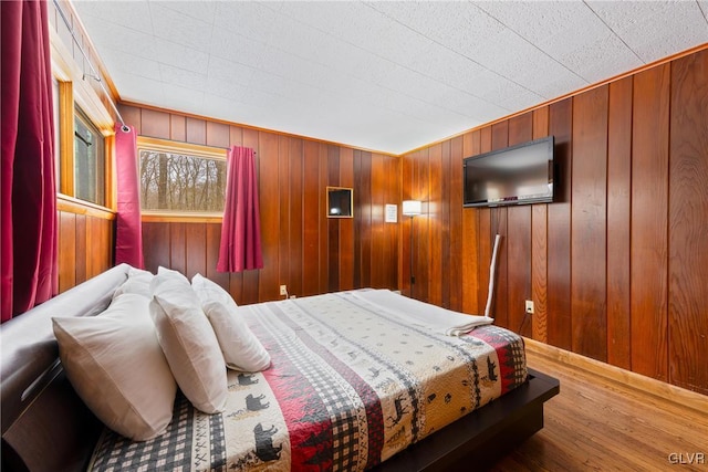 bedroom featuring wood-type flooring and wooden walls