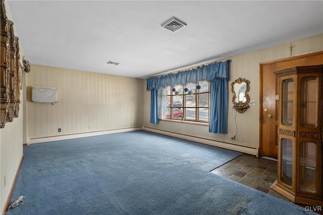 carpeted spare room featuring a baseboard heating unit