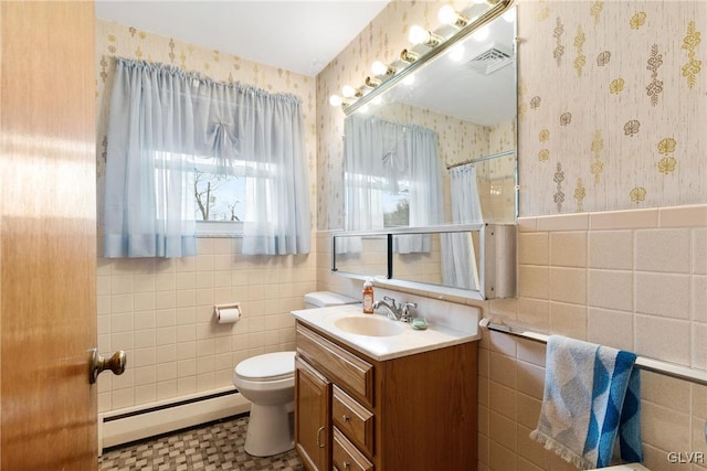 bathroom with tile walls, a baseboard heating unit, vanity, a shower with curtain, and toilet