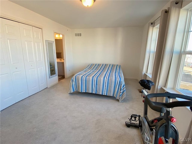 bedroom with light colored carpet and a closet