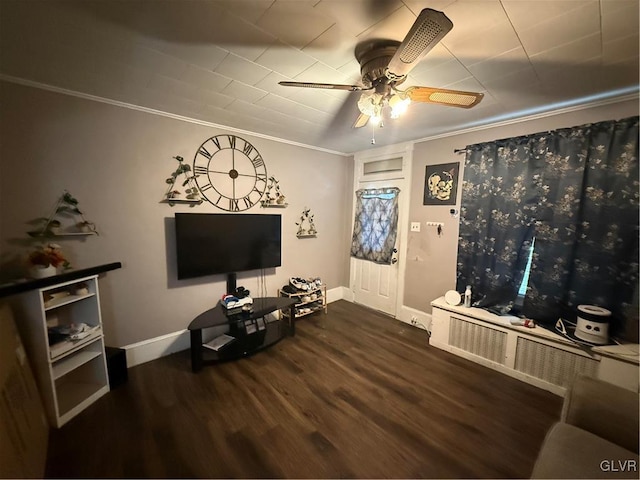 living room featuring dark wood-type flooring, ornamental molding, and ceiling fan