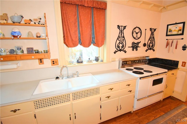 kitchen with sink, dark wood-type flooring, white range with electric stovetop, and white cabinetry