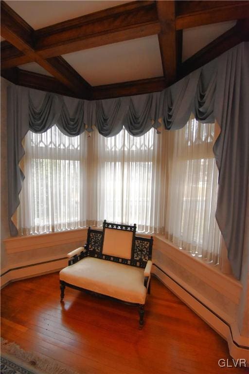 sitting room featuring coffered ceiling, hardwood / wood-style flooring, a baseboard heating unit, and beam ceiling