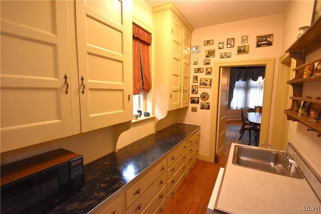 kitchen featuring white cabinetry, sink, and dark wood-type flooring