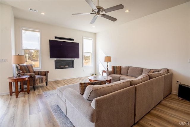 living room with ceiling fan and light hardwood / wood-style floors