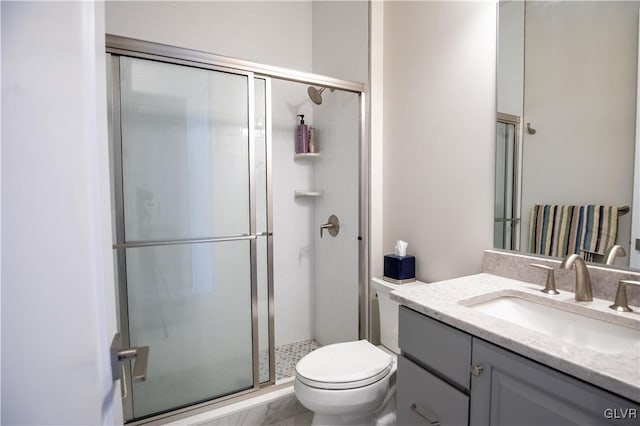 bathroom with vanity, toilet, and a shower with shower door