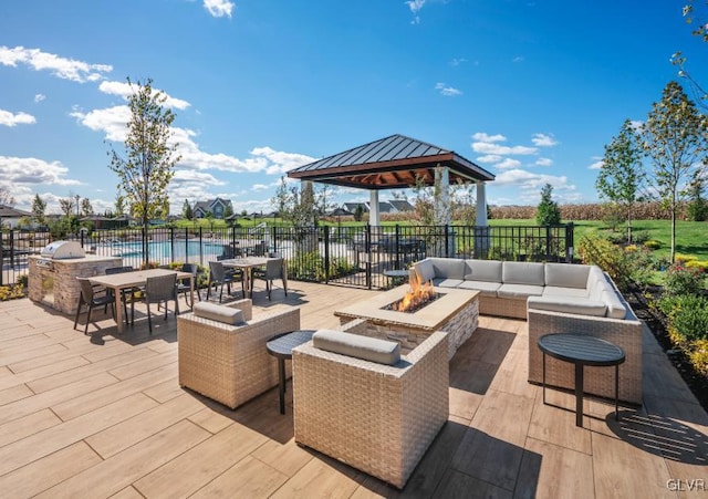 view of patio featuring a gazebo, a water view, and an outdoor living space with a fire pit