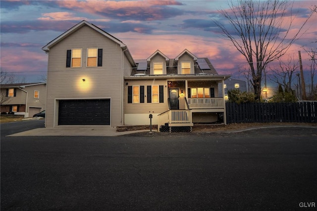 view of front of house with a garage, solar panels, and a porch