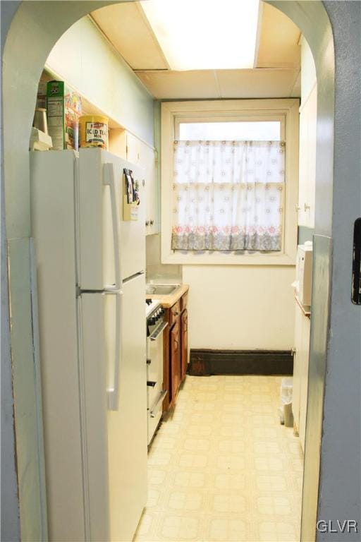 kitchen featuring range and white fridge