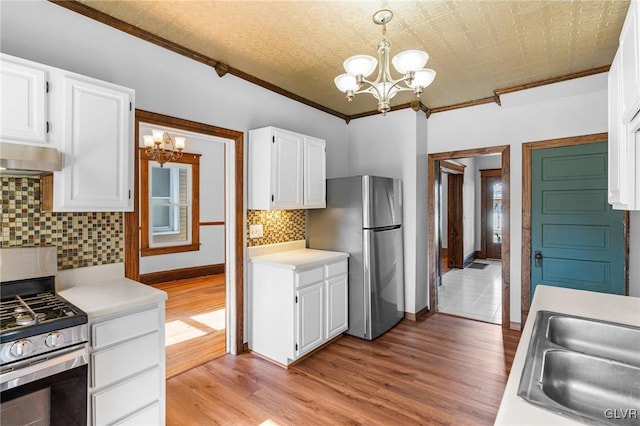 kitchen featuring decorative light fixtures, stainless steel appliances, and white cabinetry