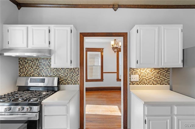 kitchen featuring white cabinetry, gas stove, wood-type flooring, crown molding, and decorative backsplash