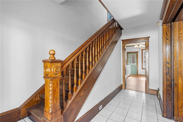 staircase with tile patterned flooring and a chandelier