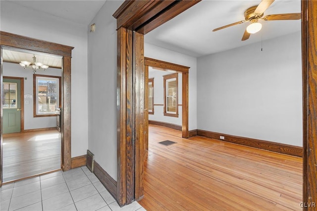 hall featuring light wood-type flooring and a notable chandelier