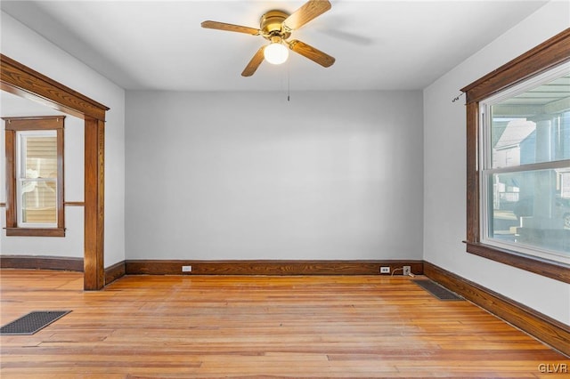 empty room with ceiling fan and light hardwood / wood-style flooring