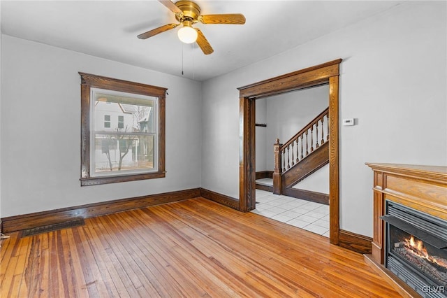 unfurnished living room featuring ceiling fan and light hardwood / wood-style flooring