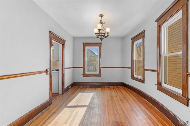 empty room featuring light hardwood / wood-style flooring and a chandelier