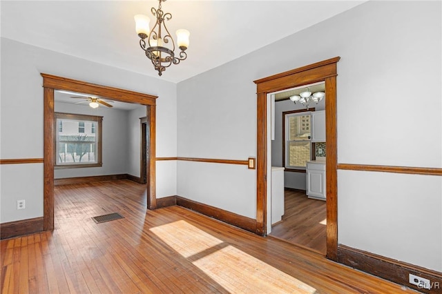 unfurnished room with hardwood / wood-style floors and a chandelier