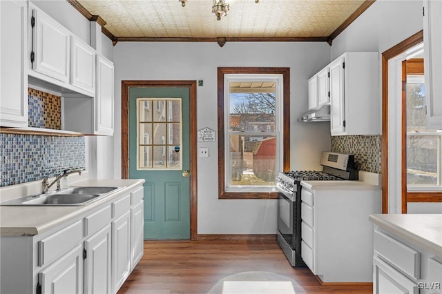 kitchen featuring white cabinets, sink, stainless steel range with gas cooktop, and ornamental molding