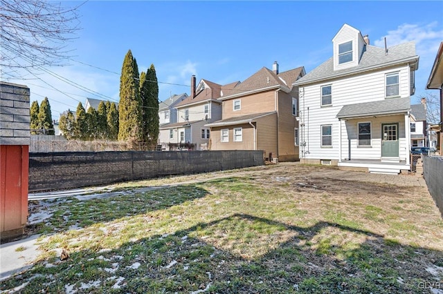 rear view of property featuring a lawn