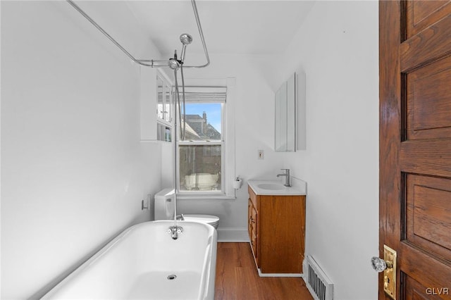 bathroom with vanity, toilet, a tub, and hardwood / wood-style floors