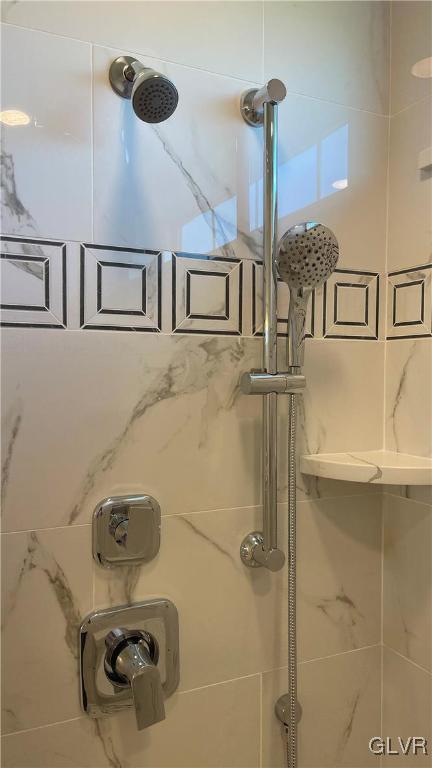 interior details featuring a tile shower